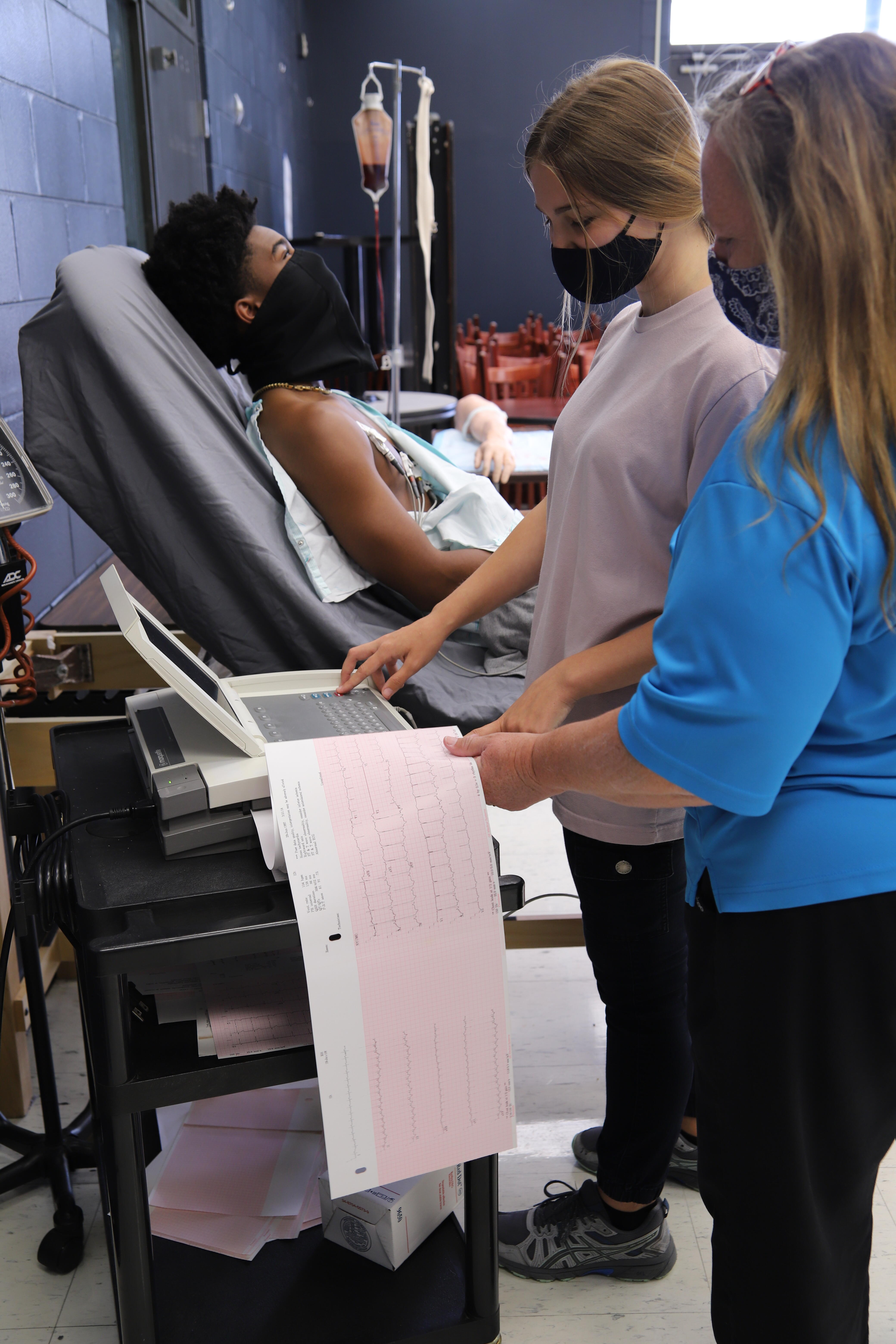 students working with an EKG machine